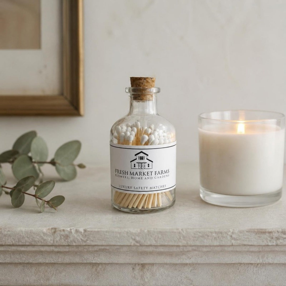 White matches in a glass jar beside a lit candle